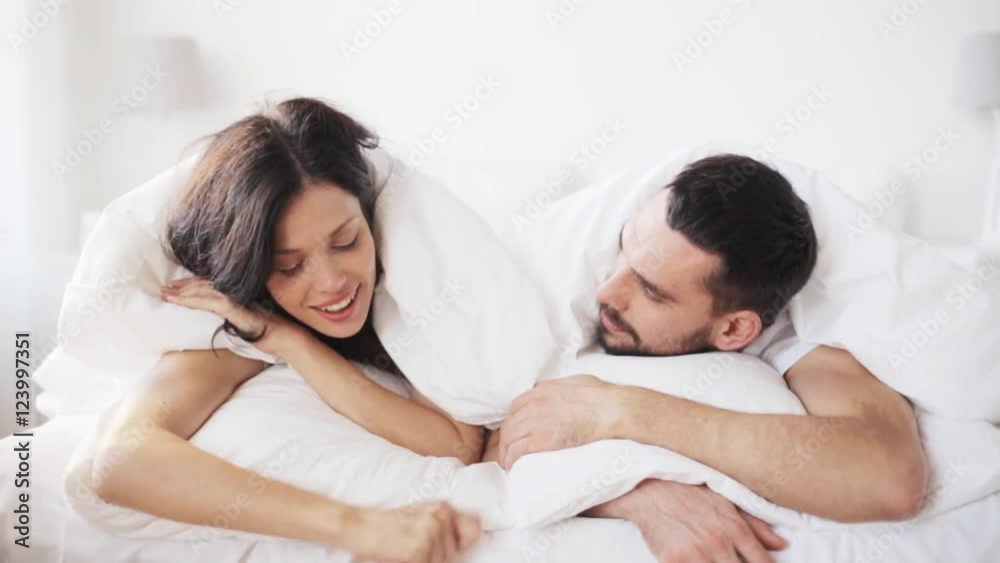 happy couple lying in bed at home happy couple lying in bed at home