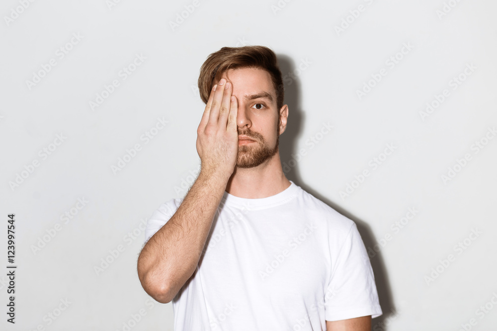 An emotional image of a young caucasian man with a beard in a white t-shirt on a bright background An emotional image of a young caucasian man with a beard in a white t-shirt on a bright background