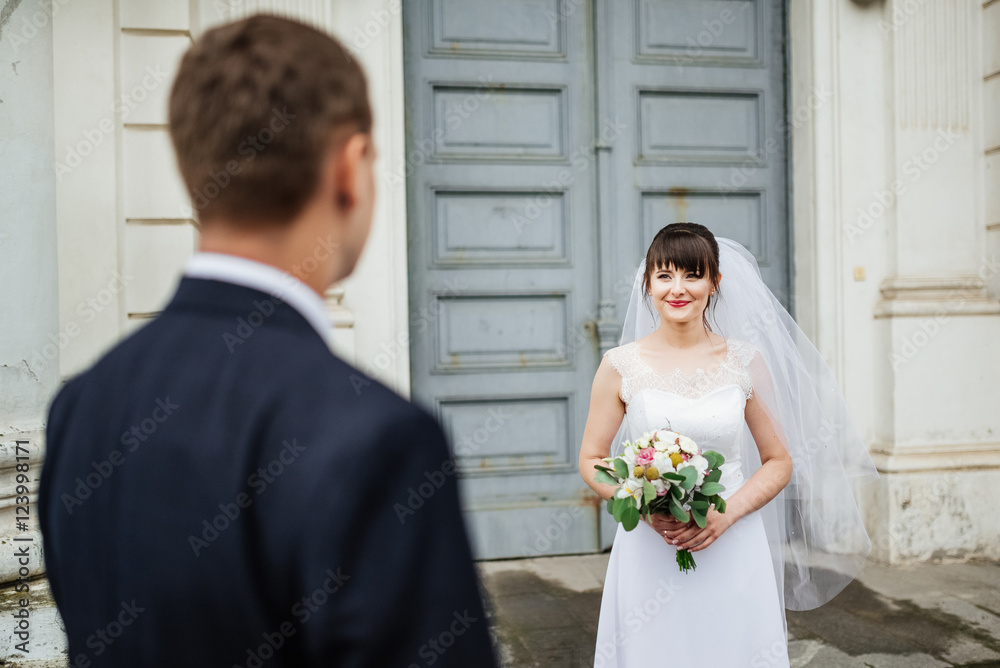 Bride and groom at wedding Day walking Outdoors near architecture. Bridal couple, Newlywed woman and man embracing with love Bride and groom at wedding Day walking Outdoors near architecture. Bridal couple, Newlywed woman and man embracing with love