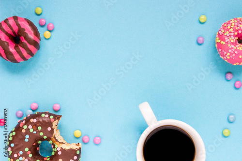 Sweet donuts with cup of coffee on the blue background.