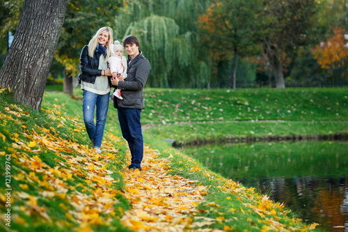 Portrait of happy family with daughter in autumn park