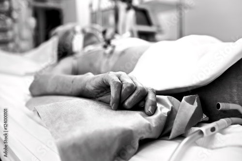 Hand extremely exhausted patients dying in a hospital bed. Black