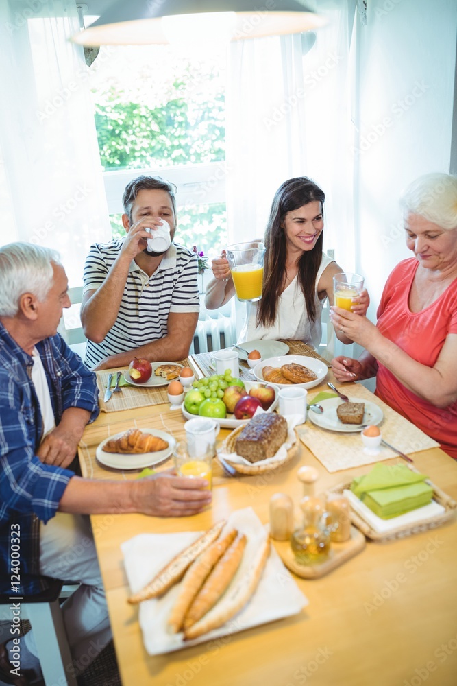 Happy couple having breakfast with their parents Happy couple having breakfast with their parents