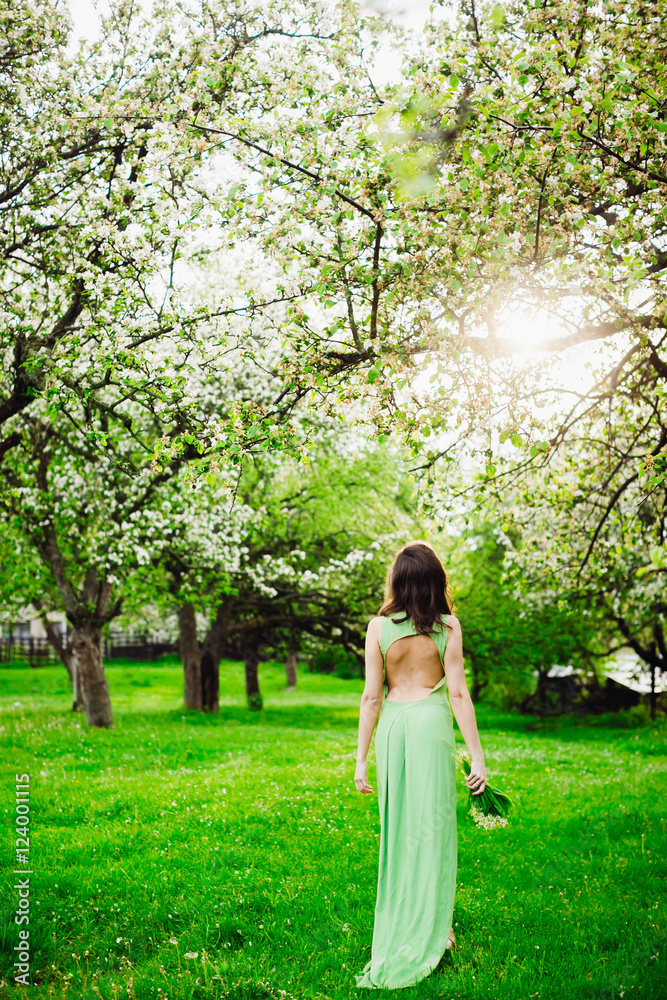 beautiful young woman walking in a green garden beautiful young woman walking in a green garden