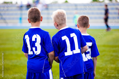 Children football soccer match. Team waiting on a bench. Ready to play soccer game
