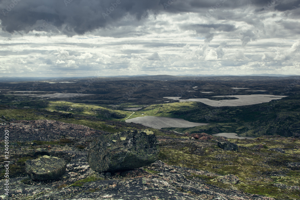 Highlands valley with views of the lake and the green hills in a sunny cloudy day. Arctic summer, the tundra, Norway.
