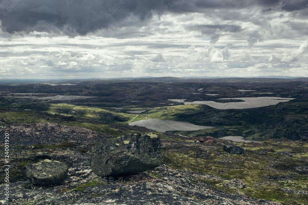 Highlands valley with views of the lake and the green hills in a sunny cloudy day. Arctic summer, the tundra, Norway. Highlands valley with views of the lake and the green hills in a sunny cloudy day. Arctic summer, the tundra, Norway.