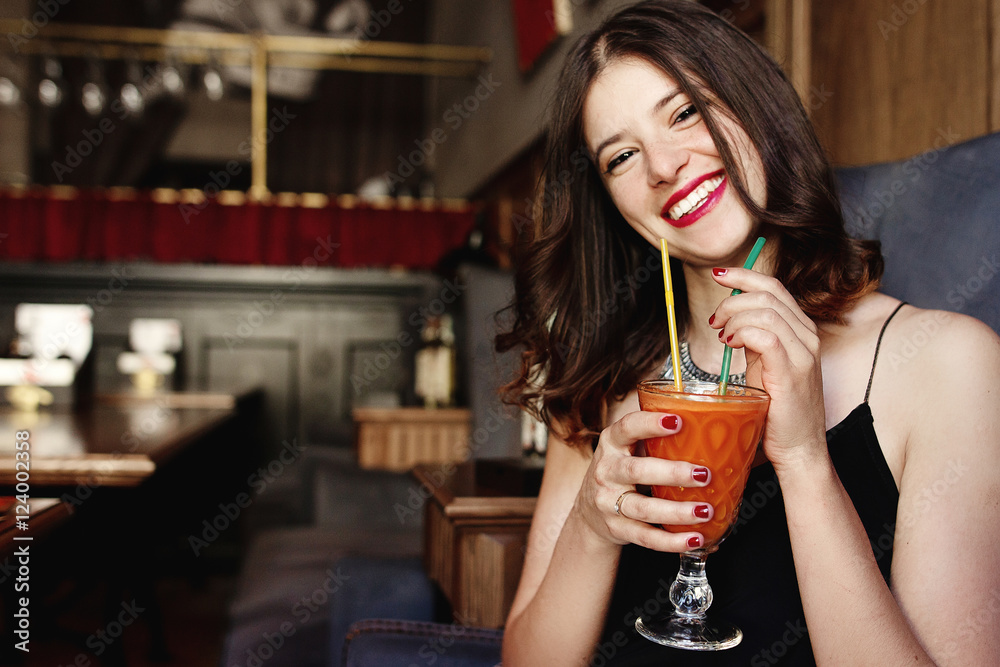 stylish happy woman holding delicious carrot fresh smoothie and