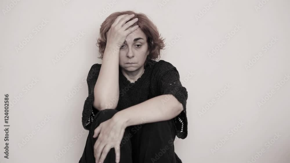 Depressed, desperate and sad woman sitting on the floor in the empty ...