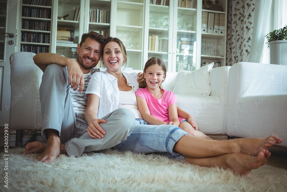 Happy family sitting on the rug in living room Happy family sitting on the rug in living room