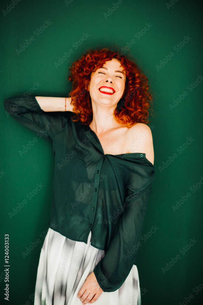 Beautiful red-haired woman stands on a green background Beautiful red-haired woman stands on a green background