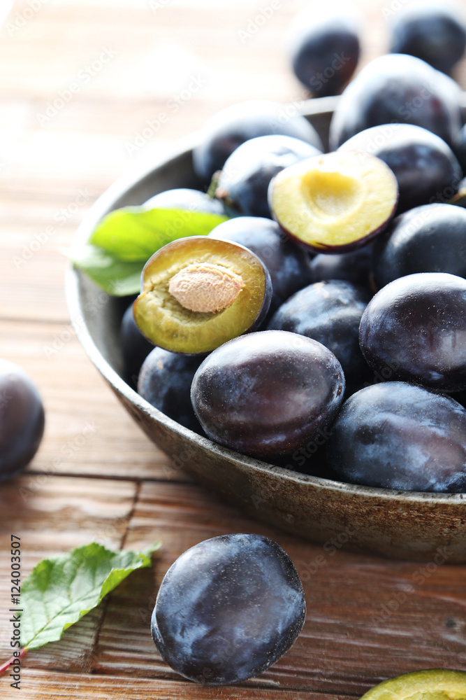 Tasty and ripe plums on brown wooden table Tasty and ripe plums on brown wooden table