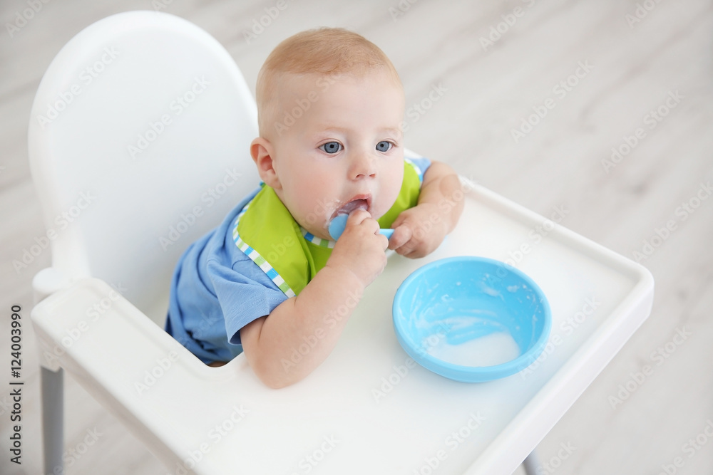 Little baby eating from bowl in kitchen Little baby eating from bowl in kitchen