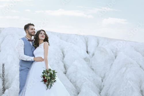 Bride and groom standing ov...