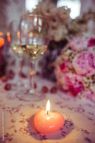 Little candle sparkles in the front of champagne flute