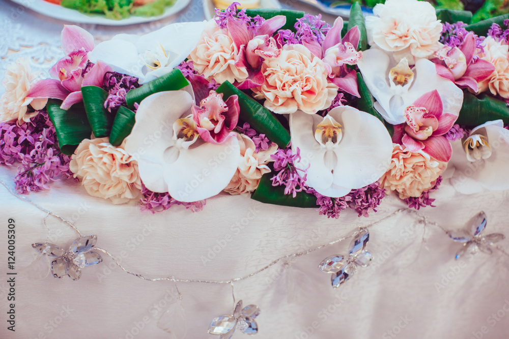 White orchids put in a flower garland lying on the dinner table White orchids put in a flower garland lying on the dinner table