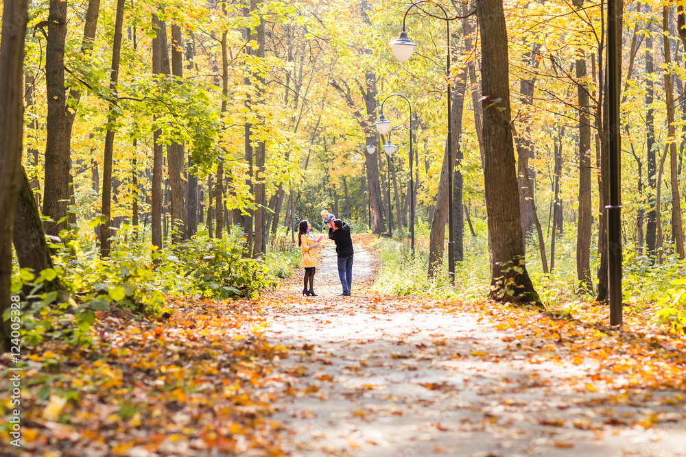 Fototapeta premium happy young family with their daughter spending time outdoor in the autumn park.