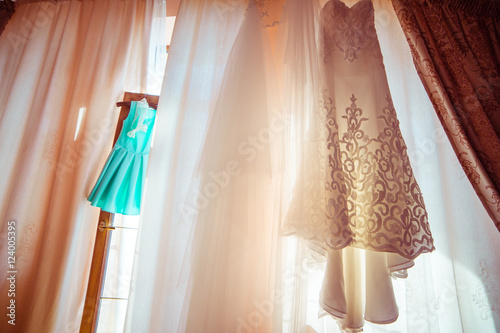 Little mint dress hangs on the wooden door to the balcony