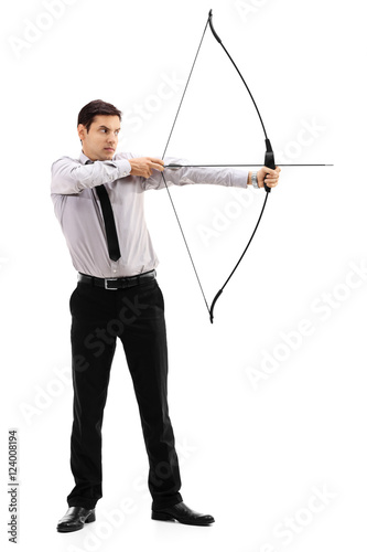 Young businessman aiming with a bow and arrow