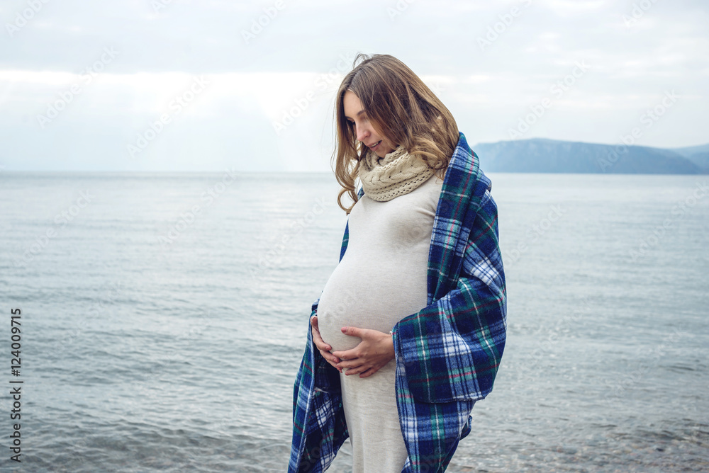 Young beautiful pregnant woman wrapped in a blanket