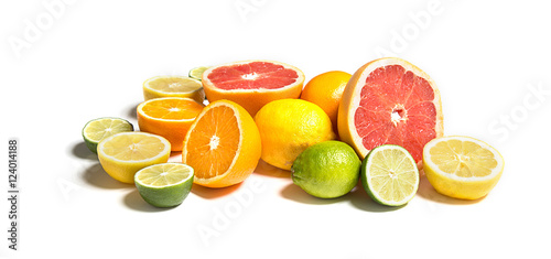 Cut citruses of different colorson white. Sliced and whole lemon, orange, lime, grapefruit photo