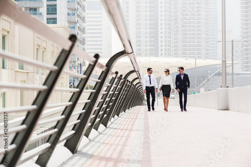 Business colleagues walking and talking at Dubai Marina. photo