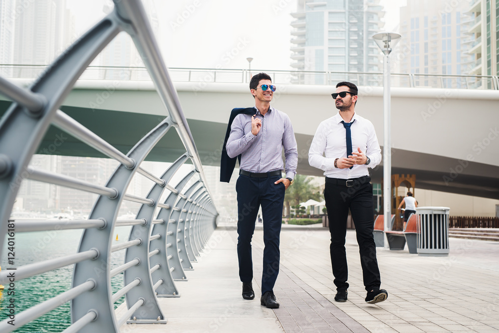 Two businessmen talking during the walk through Dubai Marina. Two businessmen talking during the walk through Dubai Marina.