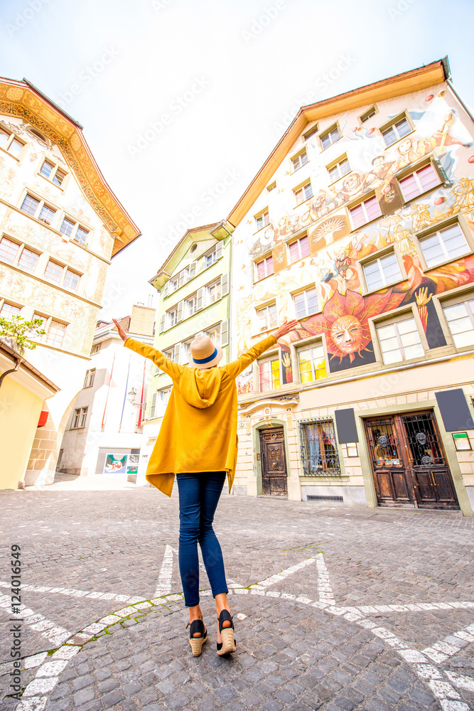 Young woman on the square with beautiful old buildings in the old town of Lucerne city in Switzerland