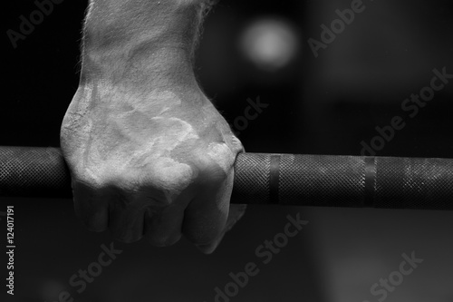 Closeup of male hand holding barbell photo