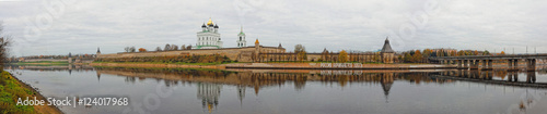 Panoramic view of Pskov Kremlin. Trinity Cathedral in old fortress. Autumn cityscape wide panorama. Translation of the inscription on the bank: Russia starts here.