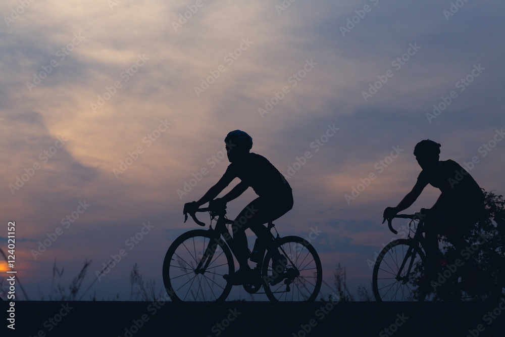 Fototapeta premium Silhouette cyclists at sunset