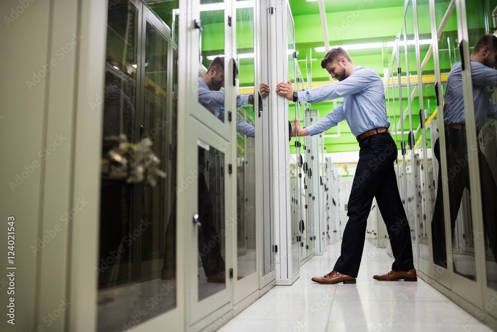 Technician adjusting server cabinet Technician adjusting server cabinet