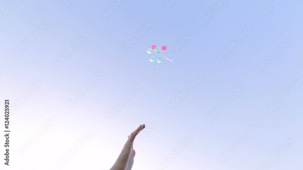 girl let go of balloons on sky background