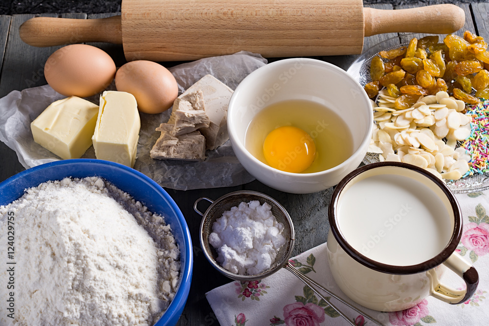 Ingredients for baking yeast cake, wooden background.