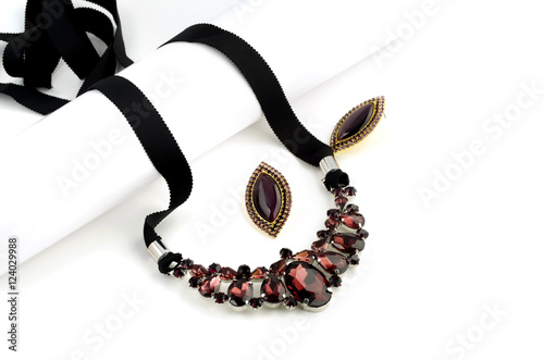 Purple glass necklace and earrings on white background