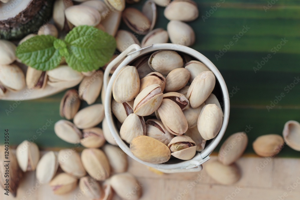Pistachio nuts is tasty on wood background.