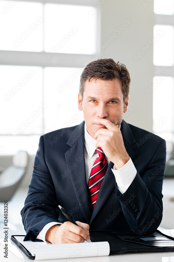 Naklejka premium Businessman writing in bright office
