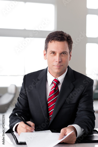 Businessman writing in bright office