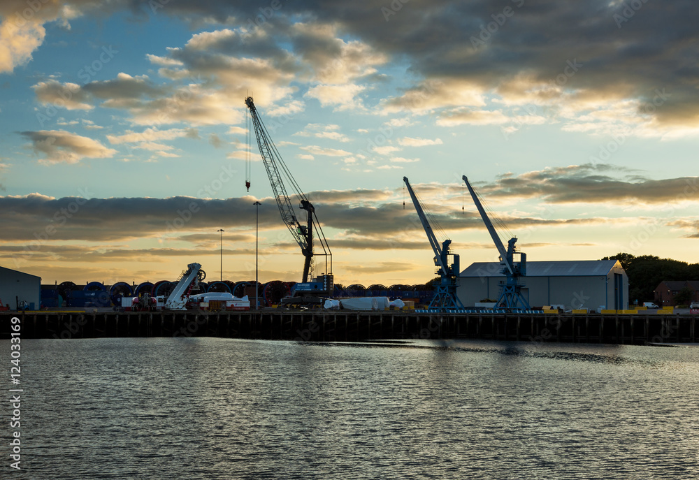 Blyth Harbour, Northumberland, England, UK. At sunset. View looking towards dock and cranes.