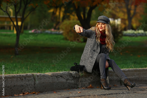 Happy young woman taking selfie in autumn park.