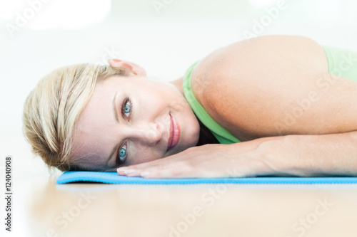 Blond woman practicing yoga in bright studio