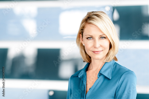 Attractive blond businesswoman in modern office lobby waiting room photo