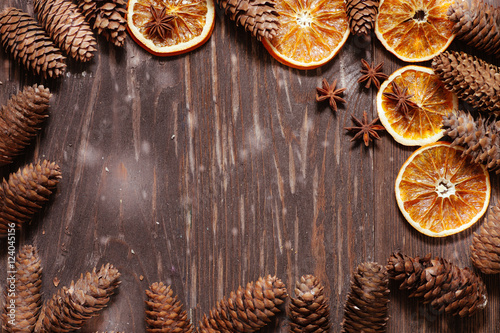 dark wood background with cones,star anise and dry orange with