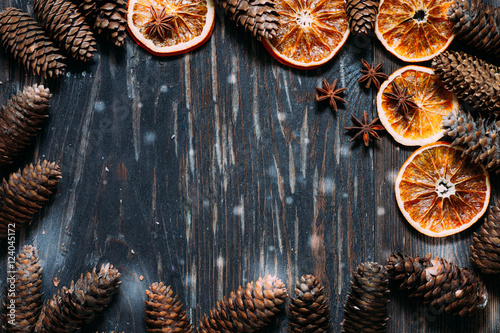 dark wood background with cones,star anise and dry orange with