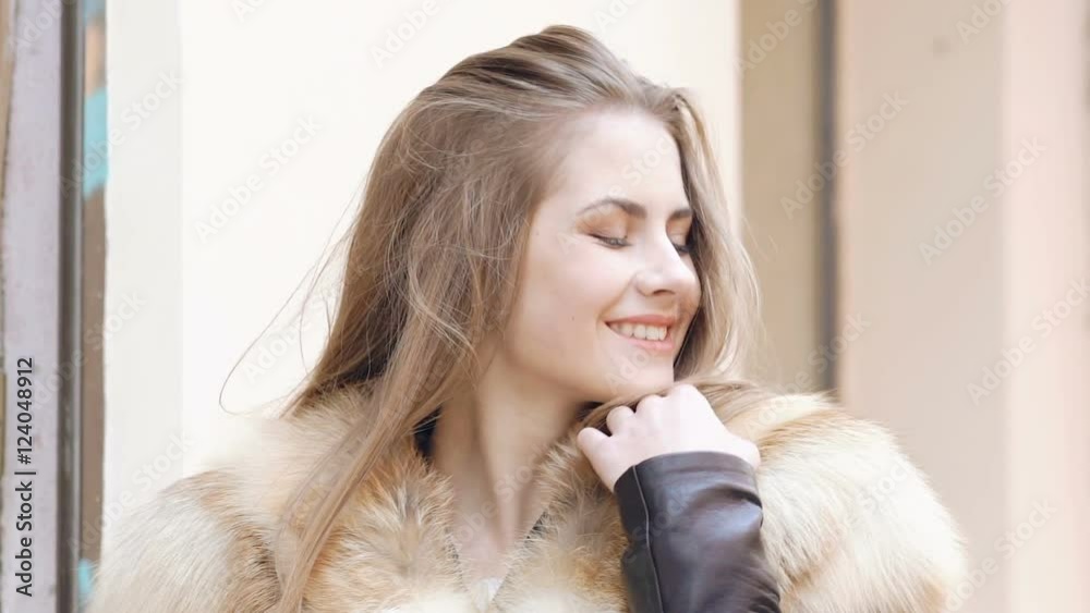 Cute girl posing in furry jacket on the street. Slow motion Cute girl posing in furry jacket on the street. Slow motion
