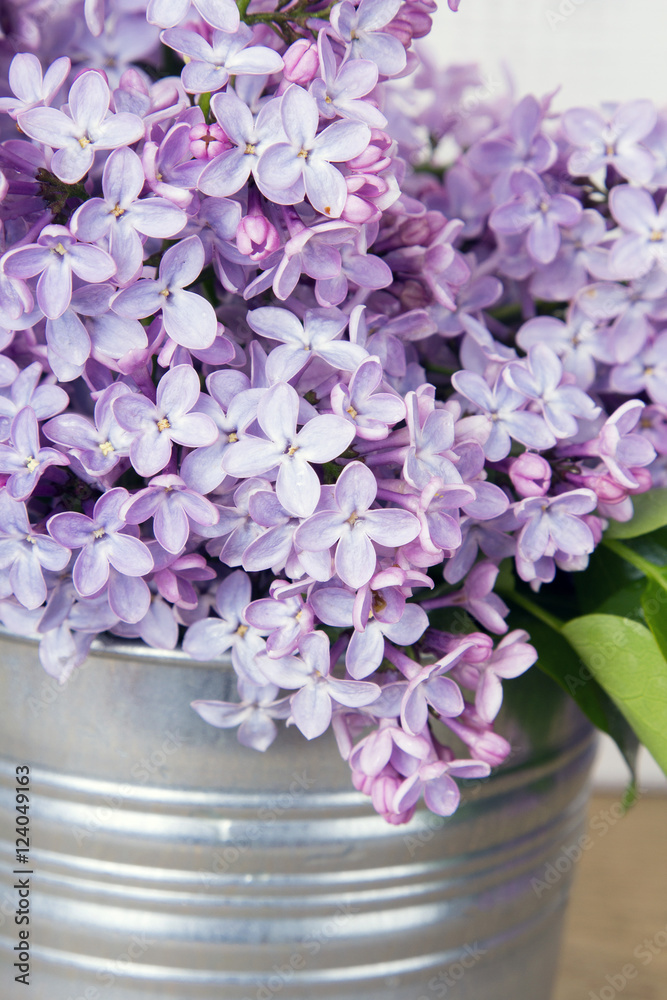 Naklejka premium lilac flowers on white wooden background