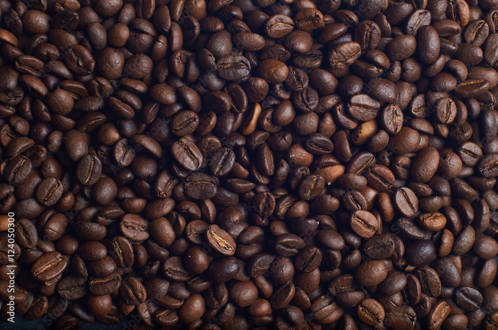 Dark brown coffee beans on the table. Background from coffee beans. Dark brown coffee beans on the table. Background from coffee beans.