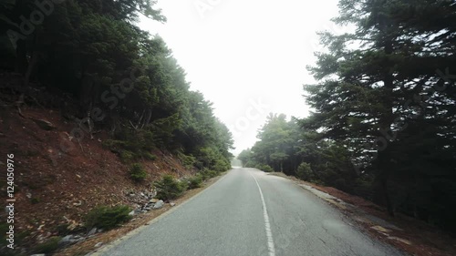 4K Pov drive on mountain autumn road, foggy.Stabilized gimbal pov wide angle driving plate shot of a car driving through a Greek mountain forest road on an overcat autumn day photo