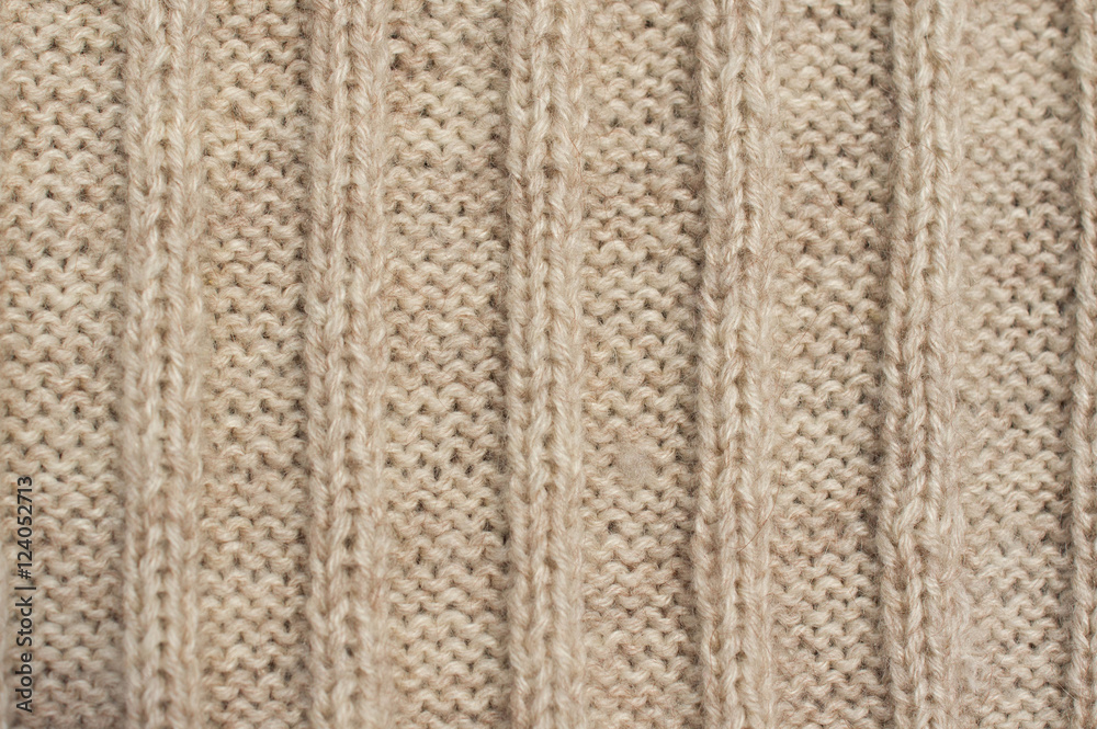 Texture of beige knitted wool sweater with ornament Texture of beige knitted wool sweater with ornament