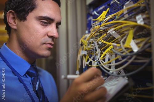 Technician maintaining record of rackmounted server on clipboar photo